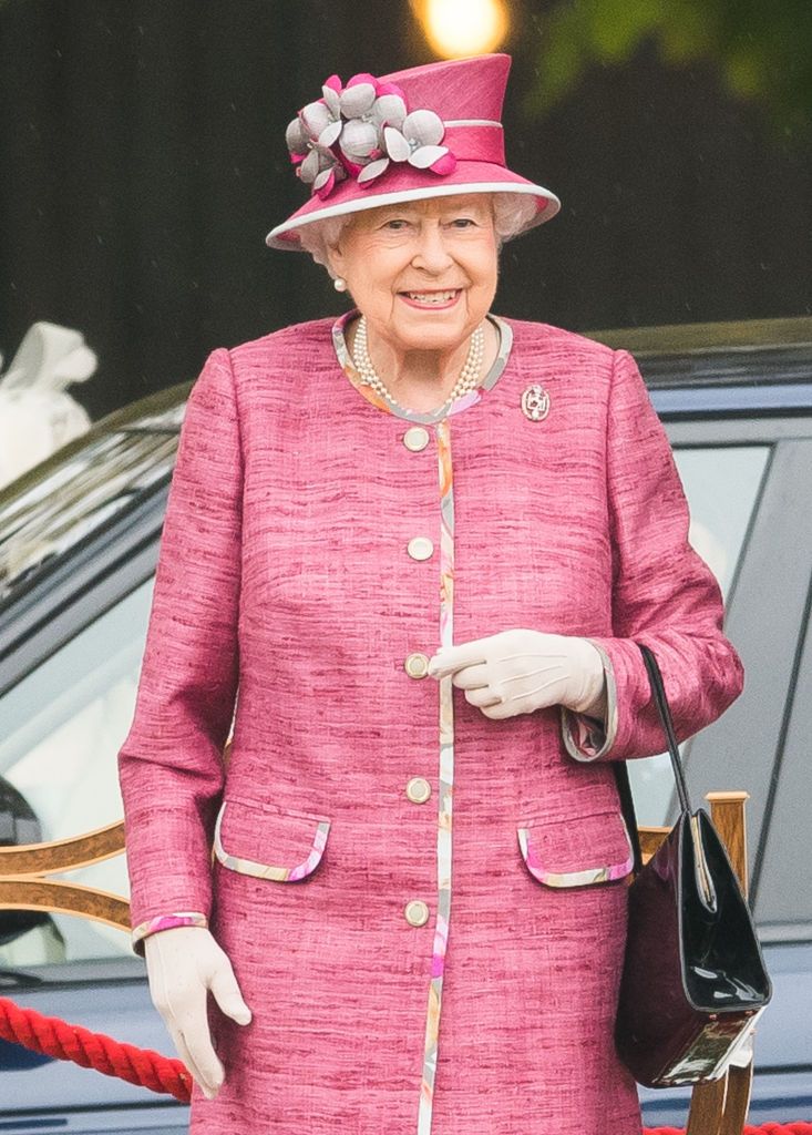 koningin elizabeth in 2017 in een roze jas met zwarte tas