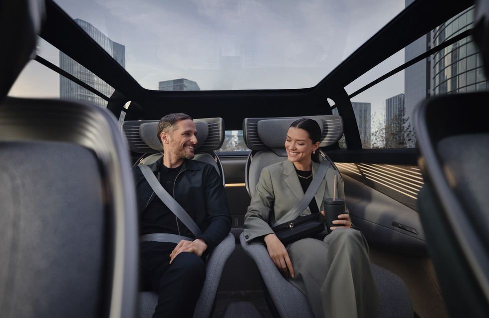 a man and woman sitting in the back of the audi urbansphere concept car