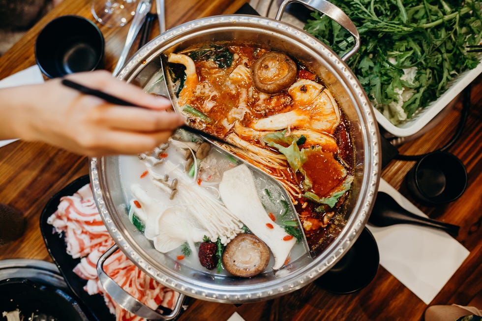 korean hot pot meal hands taking food with chopsticks