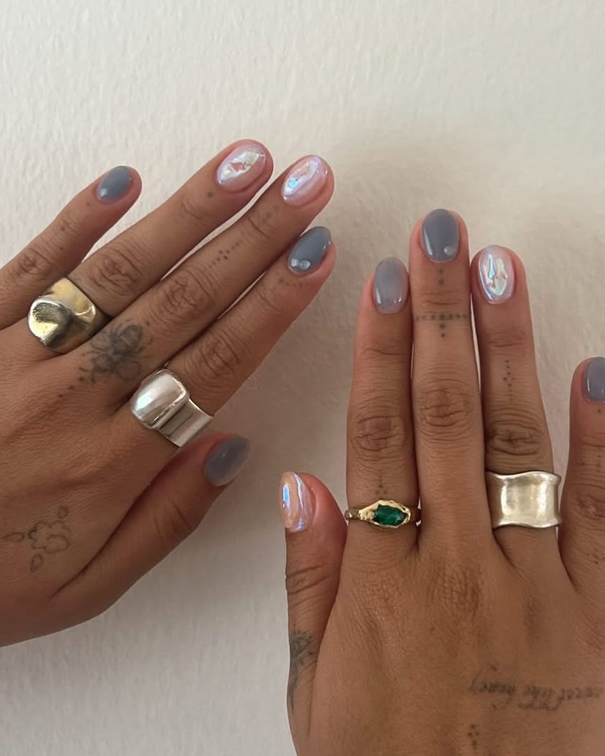 closeup of hands displaying manicured nails and various rings