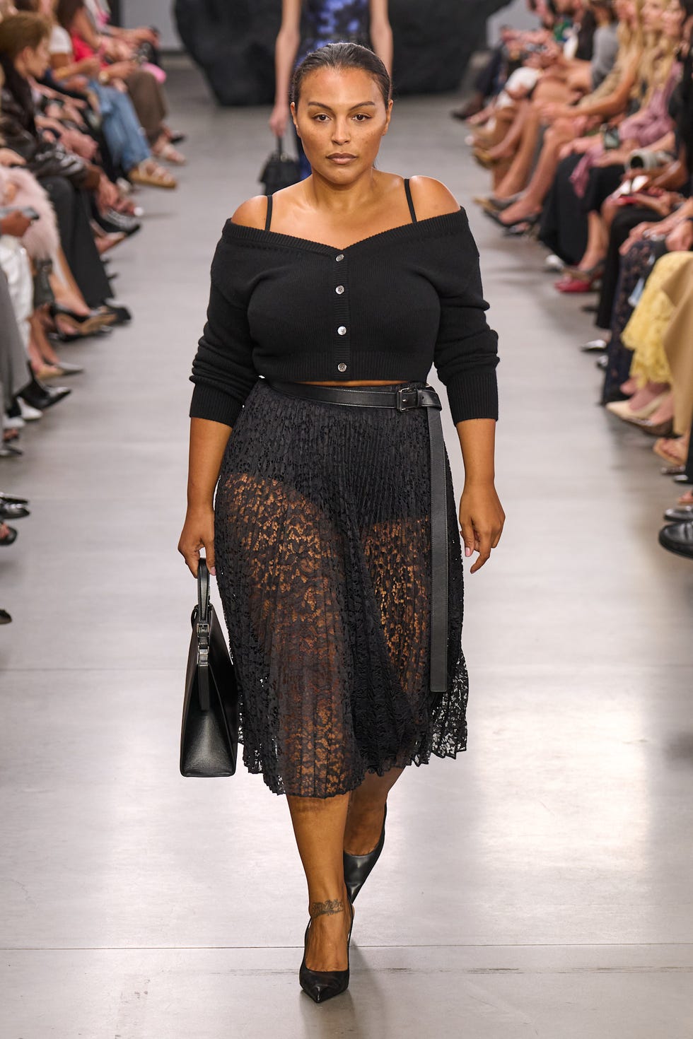 fashion model walking on the runway wearing a black outfit