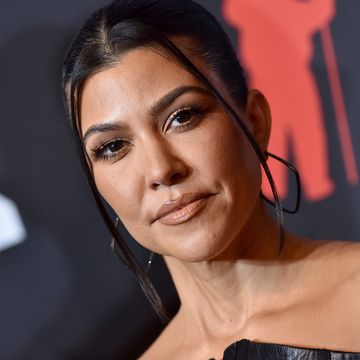 close up of kourtney kardashian with hair up and hoop earrings on a red carpet