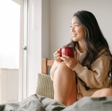 jonge vrouw drinkt thee in bed