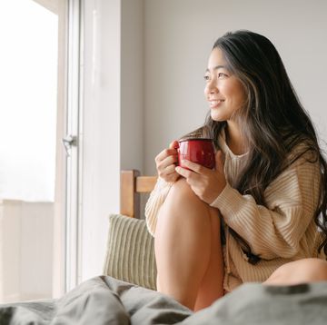 jonge vrouw drinkt thee in bed