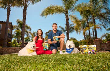 kristin and kyle juszczyk sit with their dogs on the lawn for purina for the win challenge