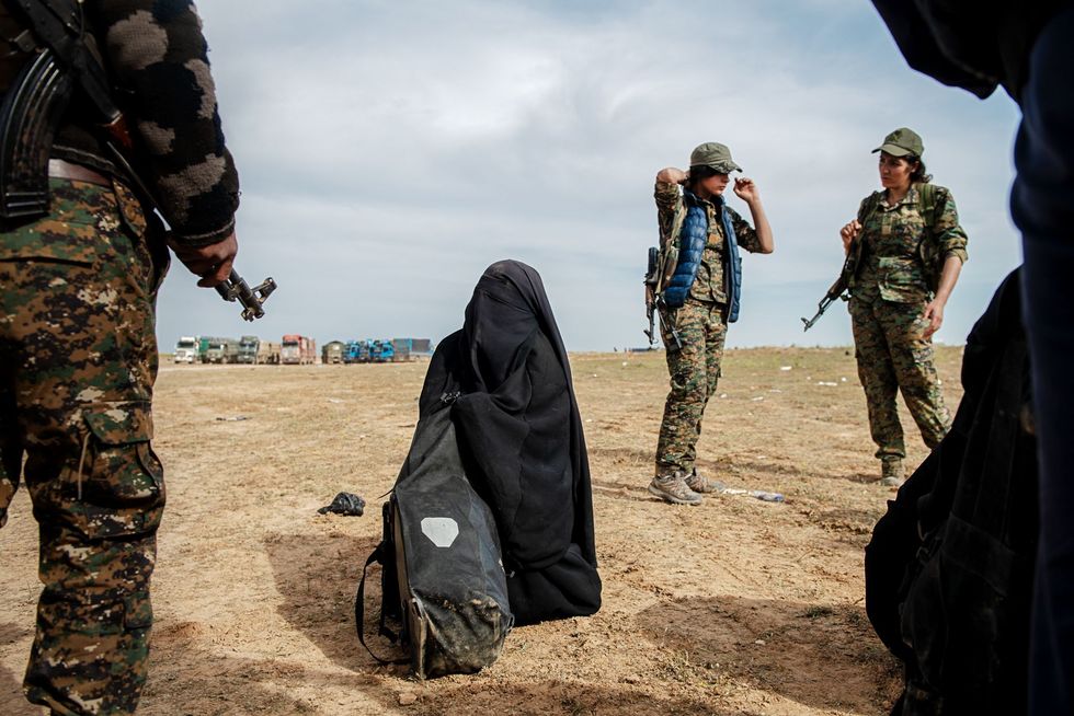 Koerdische strijders omringen een vrouw die zich overgeeft bij het vertrek van IS uit Baghouz Syri in maart 2019 Vrouwen die zich vrijwillig of onder dwang bij IS aansloten moeten worden weggeleid van de onderdrukkende versie van de islam zegt een Koerdische strijder Hun opvatting van de godsdienst klopt niet