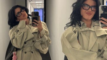 kylie jenner taking a mirror selfie wearing a beige oversized coat and glasses