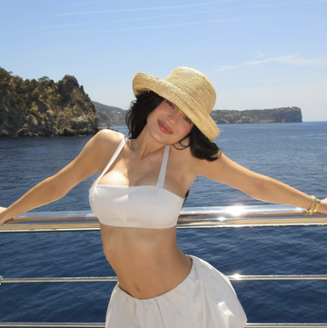 a woman in a hat and shorts standing on a boat