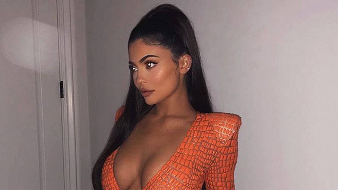 Kylie Jenner looks stunning in a form-fitting orange dress while