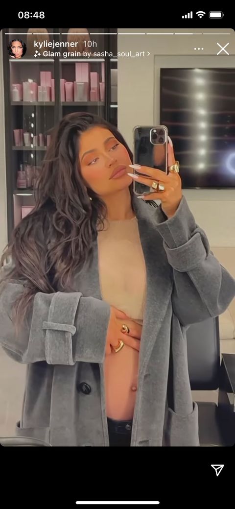 kylie jenner poses in tan crop top and gray jacket