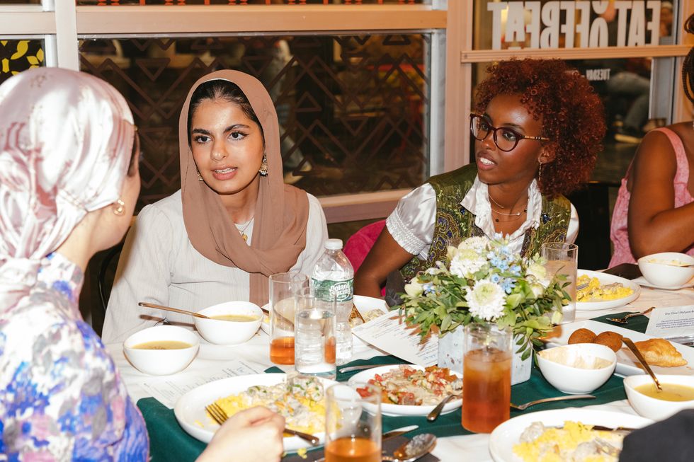 noor speaks with guests at table