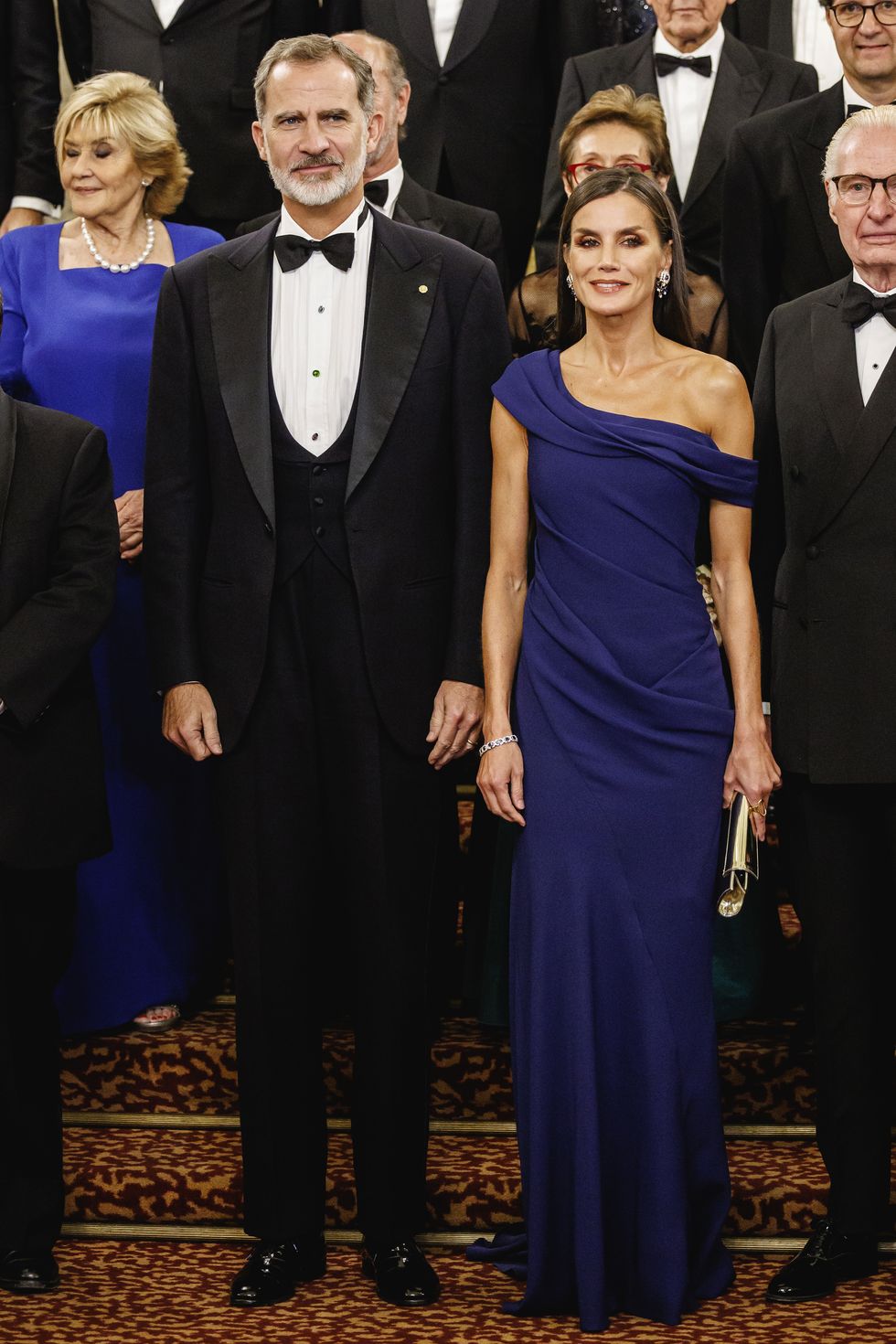 la reina letizia con vestido azul de escote bardot asimétrico de carolina herrera