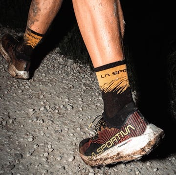 La Sportiva Prodigio Pro mudcovered running shoes and socks on a gravel path