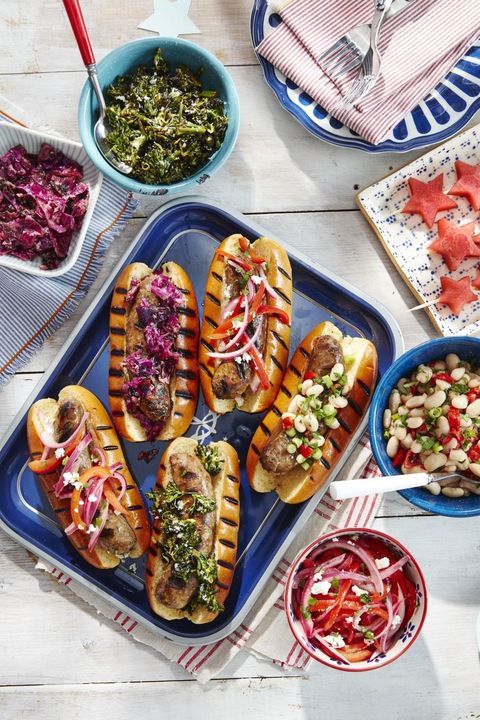 grilled sausages on grilled hot dog buns with a variety of toppings