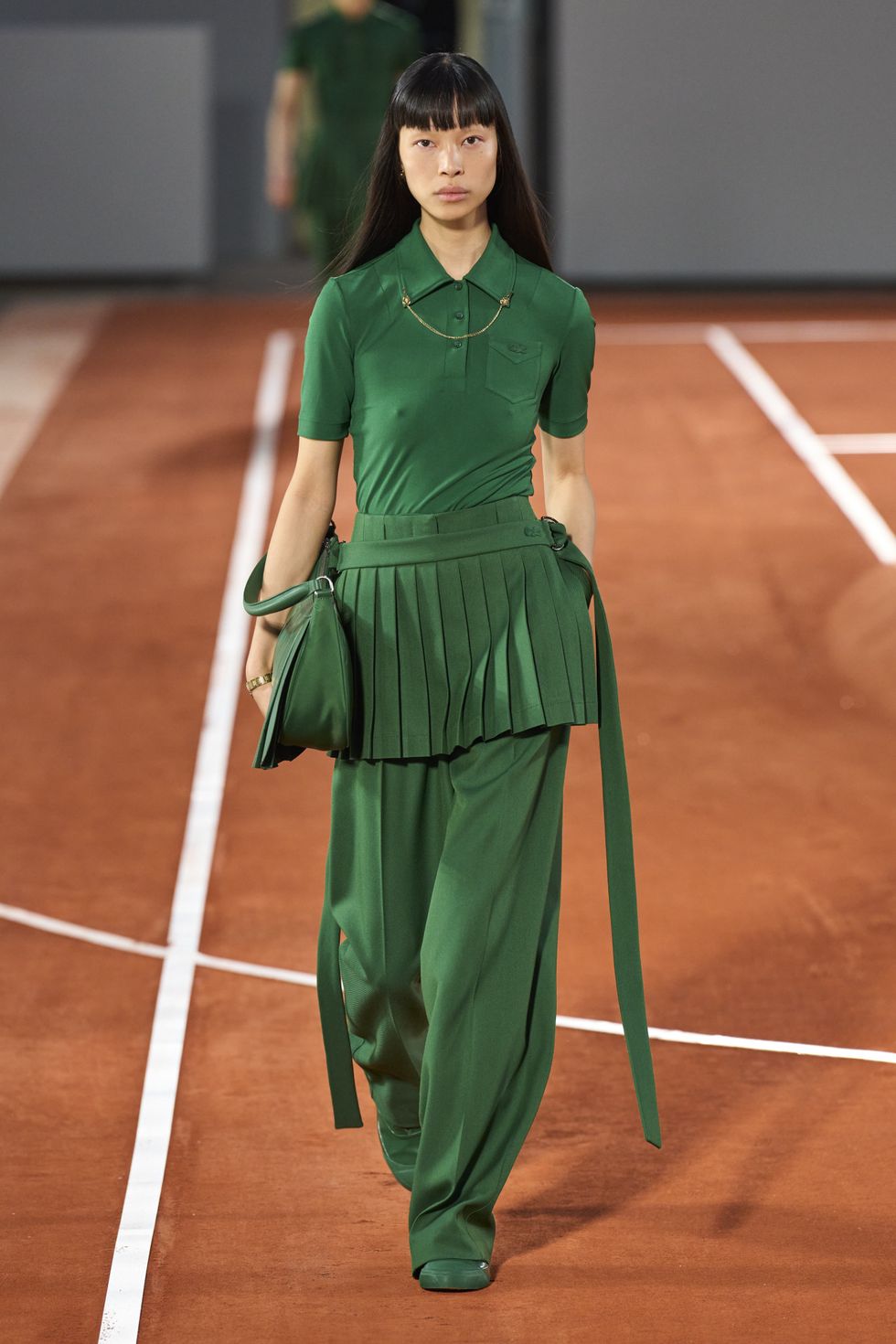 a woman in a green dress holding a tennis racket
