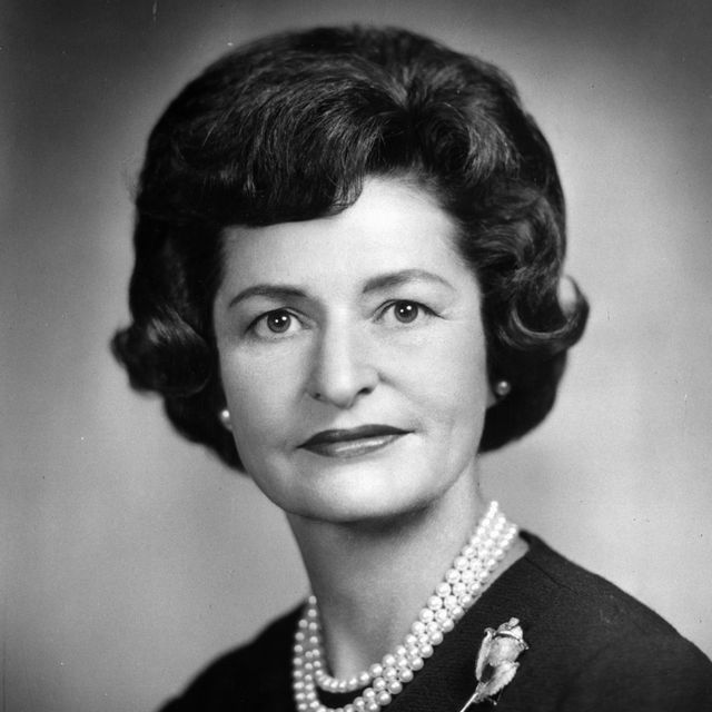 lady bird johnson wearing a pearl necklace and a rose brooch on her sweater