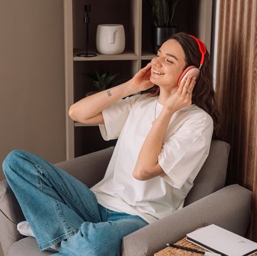 lady sitting in a chair at home listening to music on wireless headphones