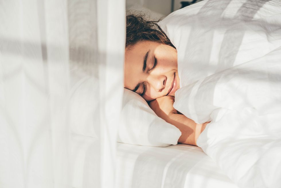 lady sleeps in bed tossing turning in dream under blanket