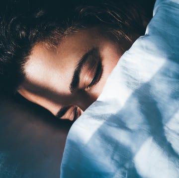 lady sleeps in bed tossing turning in dream under blanket