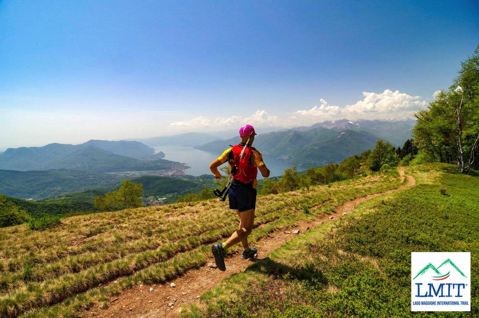 a man with a camera on a trail in a hilly landscape