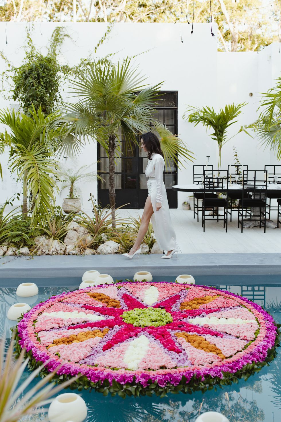 laily walking by the pool's floating floral mandala