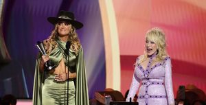 lainey wilson accepts the female artist of the year award from dolly parton onstage at 58th academy of country music awards