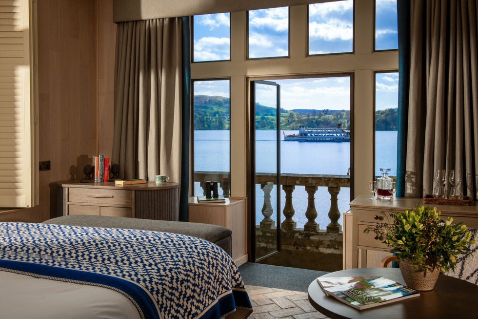 a cozy room with a view of a lake and a boat