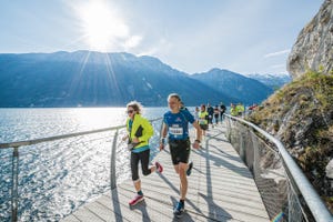 a group of people running on a bridge over water