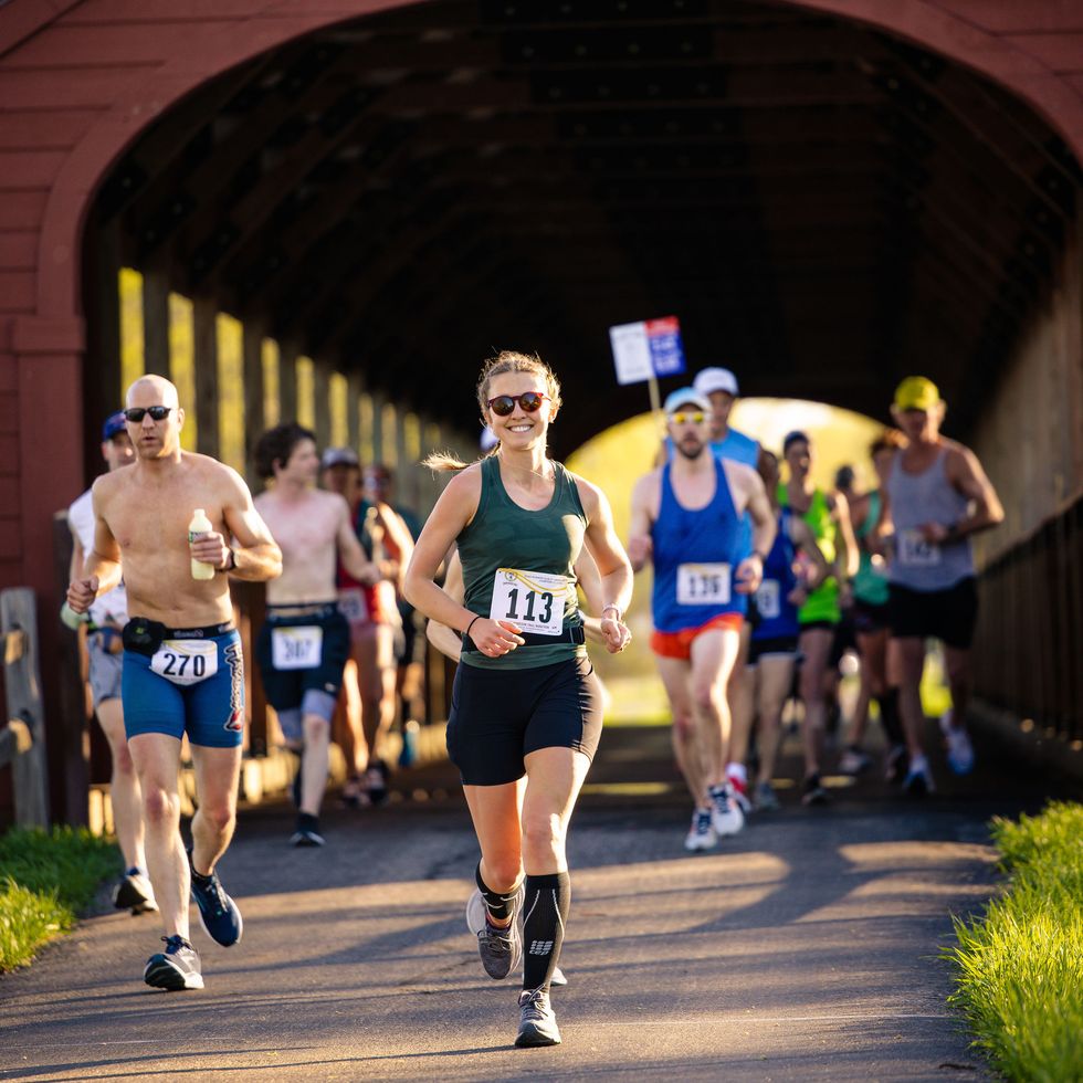 lake wobegon trail marathon runners cross a covered bridge