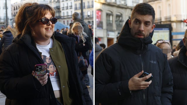 two individuals in winter jackets holding smartphones among a crowd