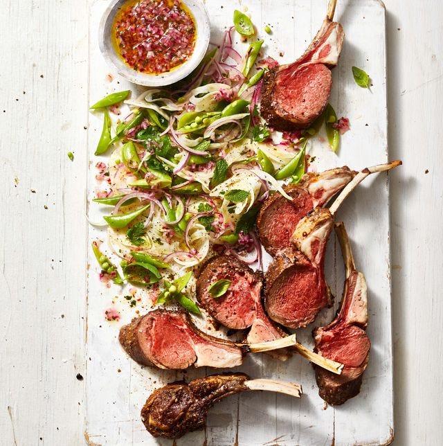 lamb chops and a snap pea salad on a wide wooden table