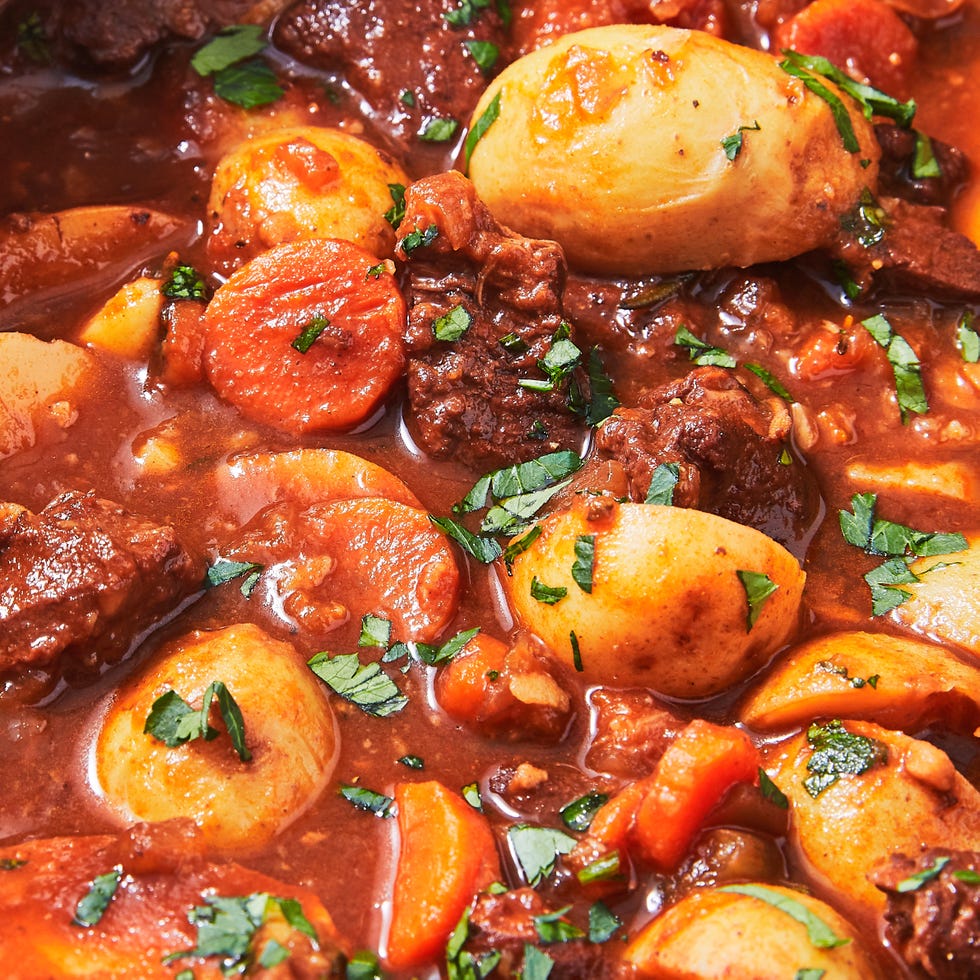 lamb stew with potatoes and carrots in a blue dutch oven