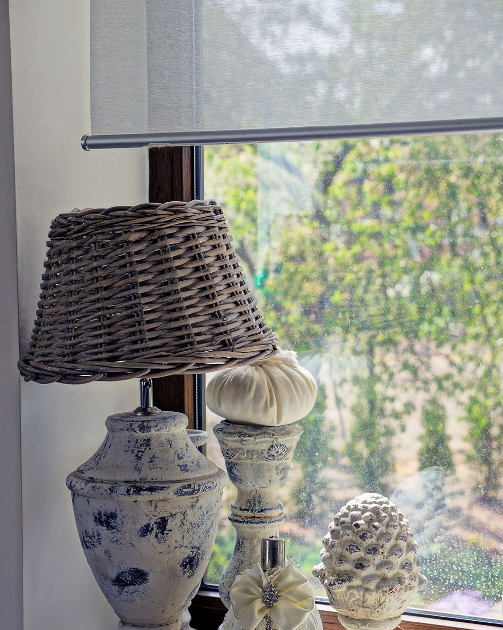 lamp bottle and decorations on the windowsill near the window