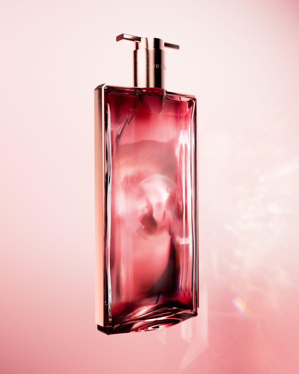 uma garrafa de perfume de vidro elegante com um líquido rosa dentro