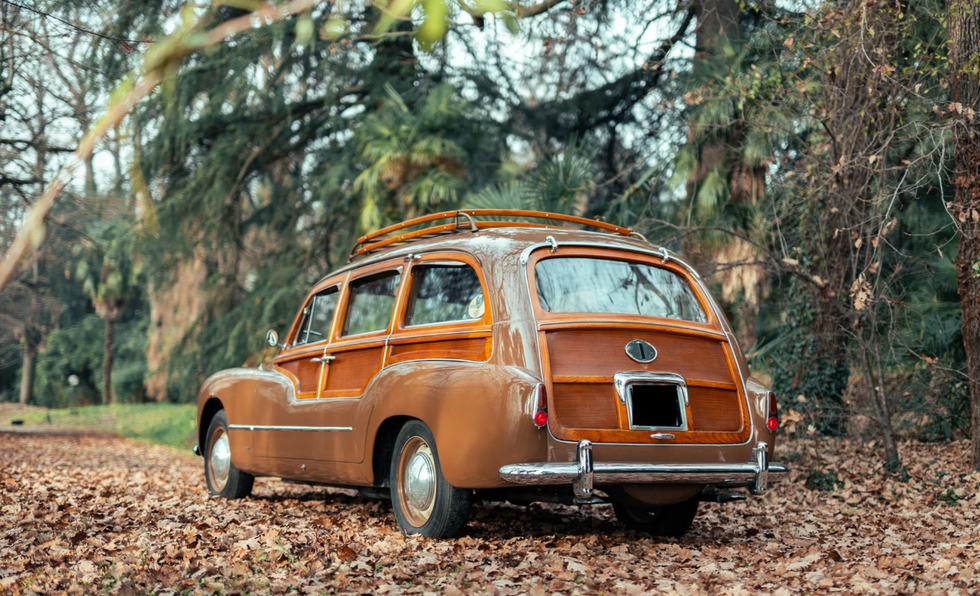 an old rusted car parked in the woods