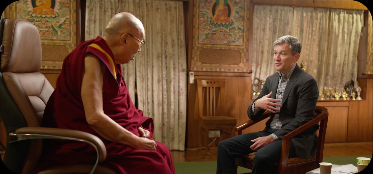 the dalai lama seated and talking with dan harris who is also seated