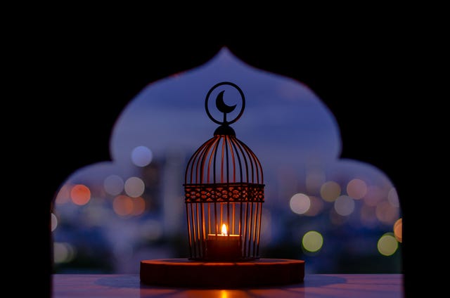 lantern that have moon symbol on top with city bokeh light