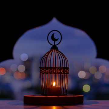 lantern that have moon symbol on top with city bokeh light