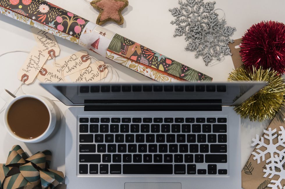 Laptop, coffee, wrapping paper and Christmas ornaments