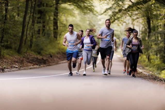 large group of athletes running a marathon on the road.