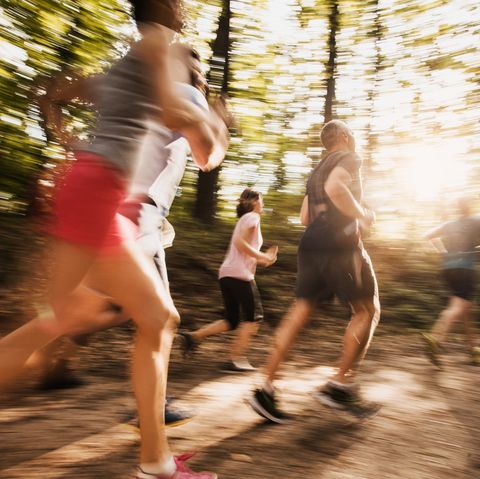 large group of people in blurred motion running a marathon in nature