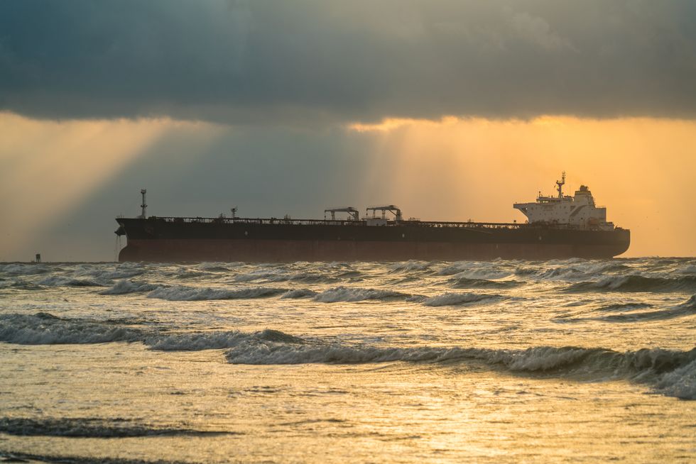Large oil tanker ship entering shipping channel in Port Aransas , Padre Island Beach sunrise reflections