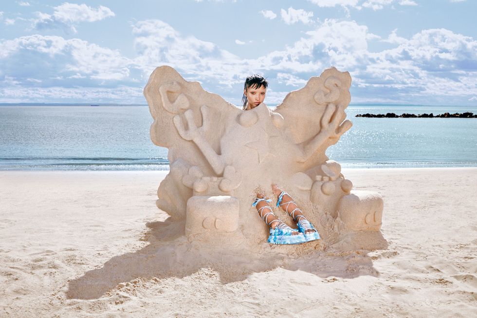 a person sitting in a sand sculpture on a beach