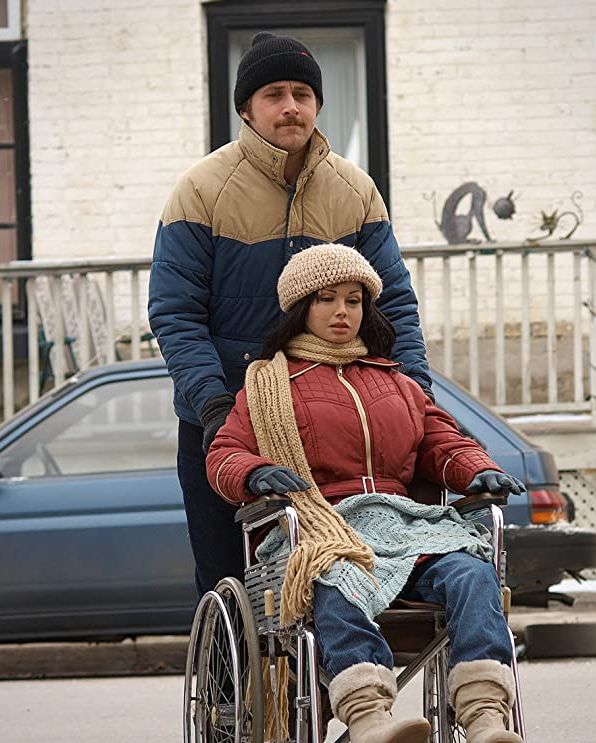 ryan gosling en una escena de lars y una chica de verdad llevando en una silla de ruedas una muñeca hinchable