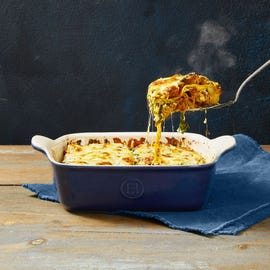 lasagna with meat sauce in a blue baking dish