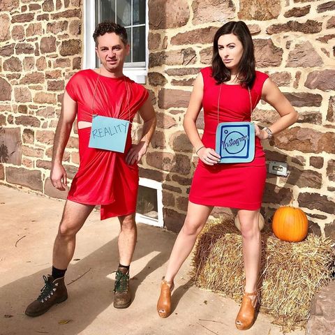 couple dressed alike in short red dresses striking a pose with woman wearing instagram sign and man wearing reality sign