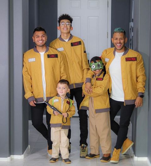family wearing ghostbusters costumes including neutral bomber jackets and name tags for stantz, spengler, venkman, zeddemore
