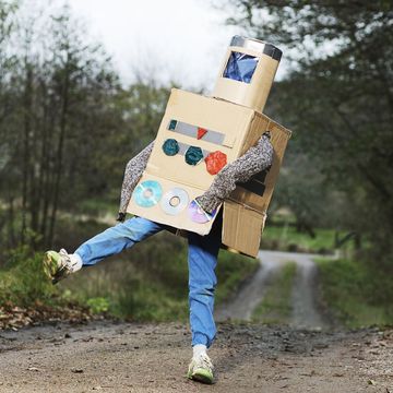 boy outdoors wearing robot halloween costume made last minute from cardboard boxes, old cds, other odds and ends