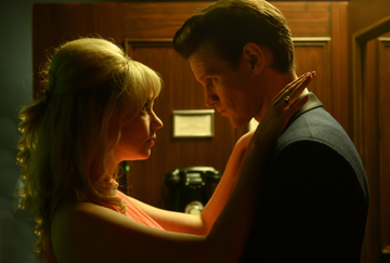 anya taylor joy and matt smith in 1960's costumes staring into each other's eyes in a tight phone booth in a scene from edgar wright's last night in soho
