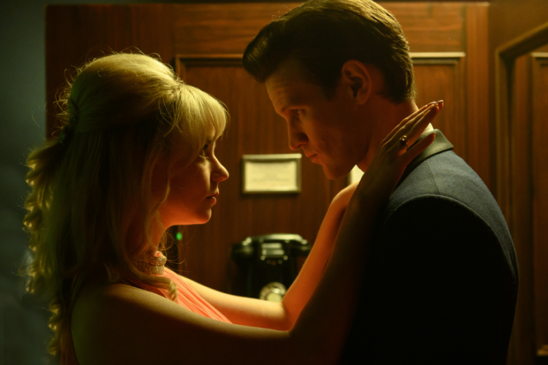 anya taylor joy and matt smith in 1960's costumes staring into each other's eyes in a tight phone booth in a scene from edgar wright's last night in soho